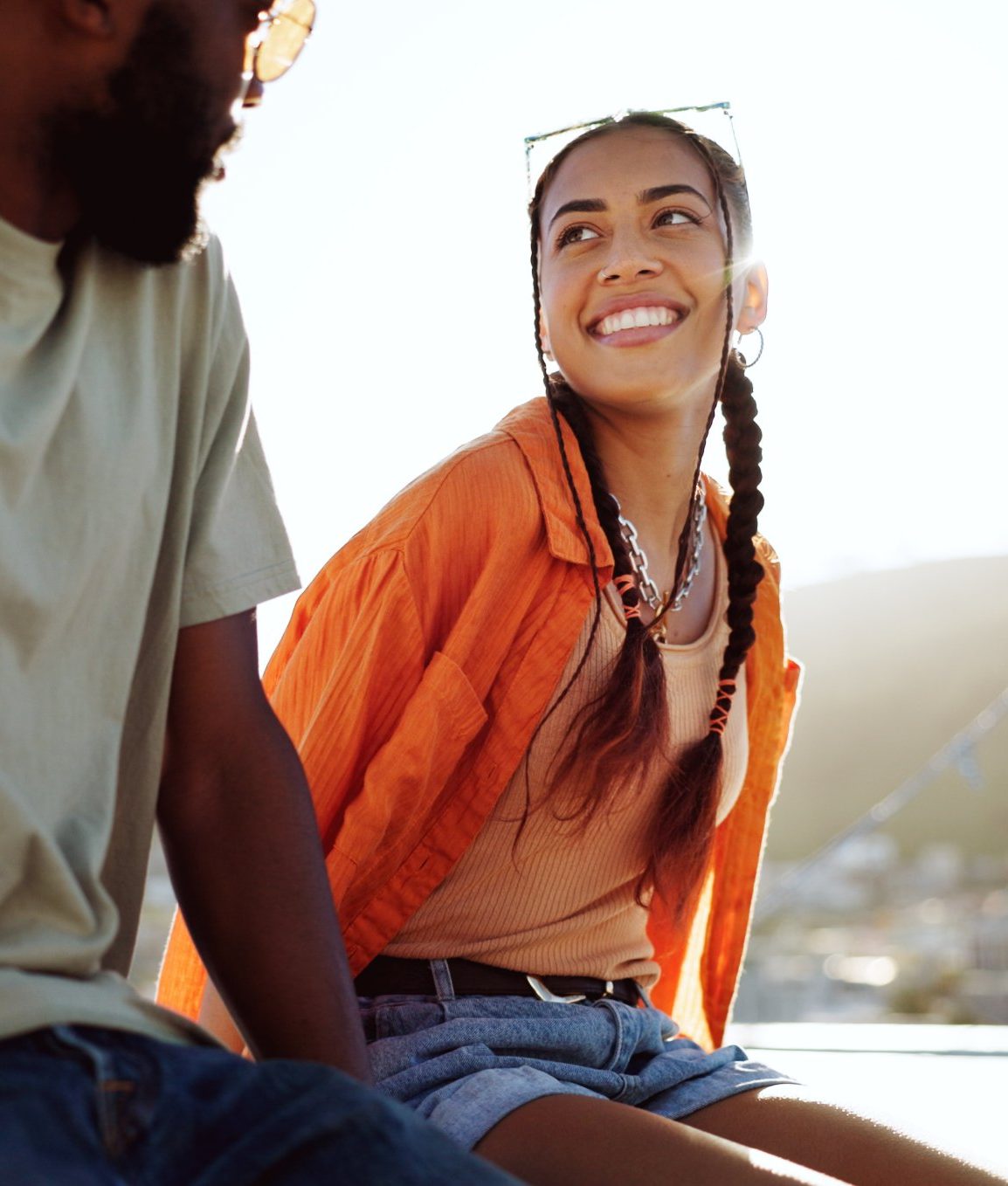Two friends sitting on a rooftop at golden hour